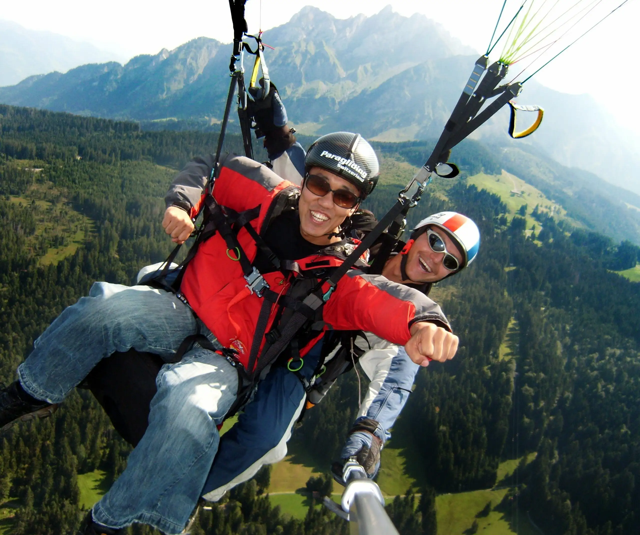 Tandem paragliding at Mount Pilatus near Lucerne: Passenger and pilot in the Superman pose soaring over the Swiss Alps.